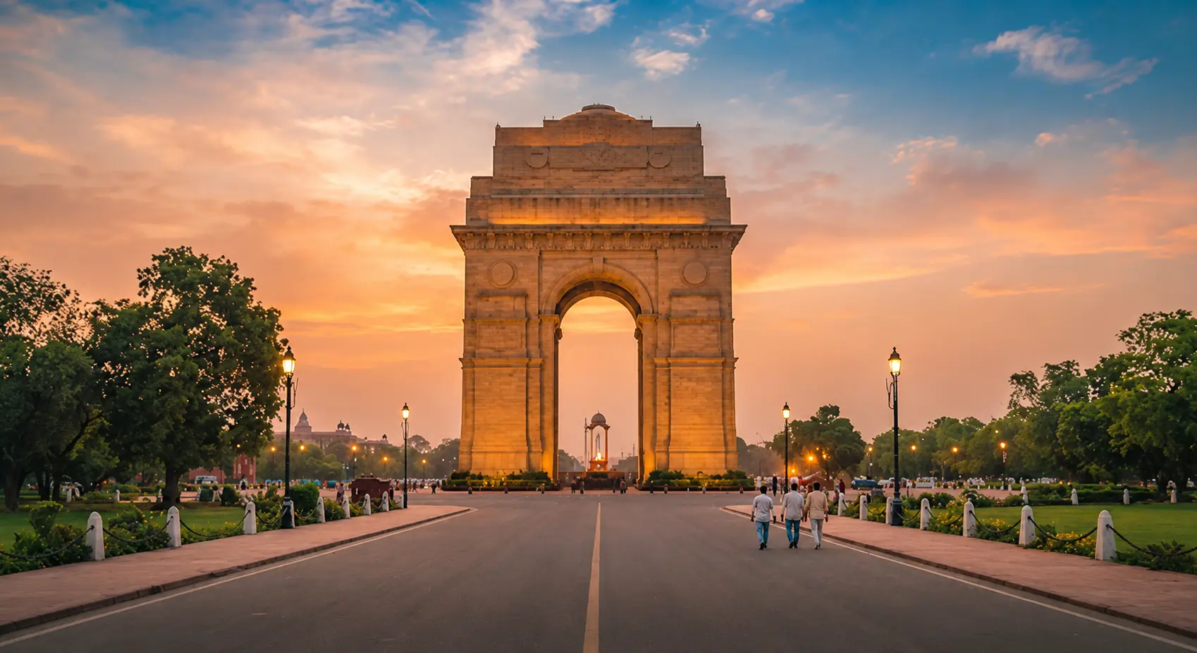 A detailed, vibrant street-level view of India Gate in New Delhi during golden hour. The majestic archway stands tall against a warm, saffron-tinted sky. The architectural details are crisp, and the surrounding space is uncluttered, emphasizing the monument's grandeur. The lighting creates a sense of warmth and invitation, perfect for an editorial travel aesthetic.