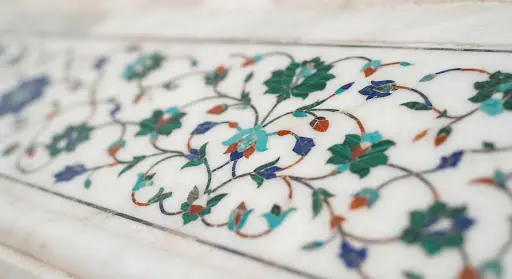 A close-up, highly detailed view of the intricate marble inlay work on the Taj Mahal, Agra. The white marble is pristine, and the floral patterns formed by semi-precious stones are sharp. The lighting is soft and natural, emphasizing the craftsmanship. This small image adds a touch of premium heritage texture to the UI card.